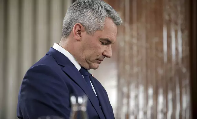 Austrian Chancellor Karl Nehammer stands at the national broadcaster studio, set up in the parliament building, in Vienna, Austria, Sunday, Sept. 29, 2024, after polls closed in the country's national election. (AP Photo/Heinz-Peter Bader)