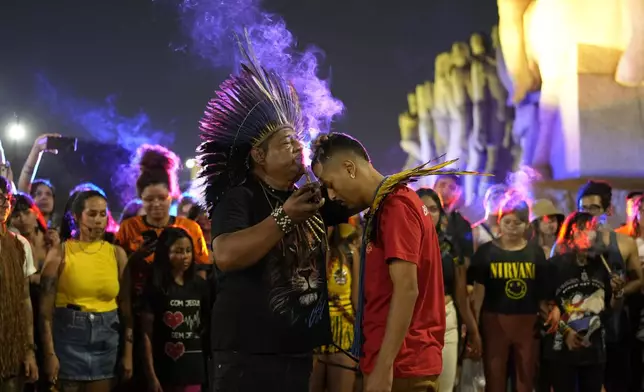 A Guarani Indigenous leader performs a religious ritual during a climate protest in Sao Paulo, Sunday, Sept. 22, 2024. (AP Photo/Andre Penner)