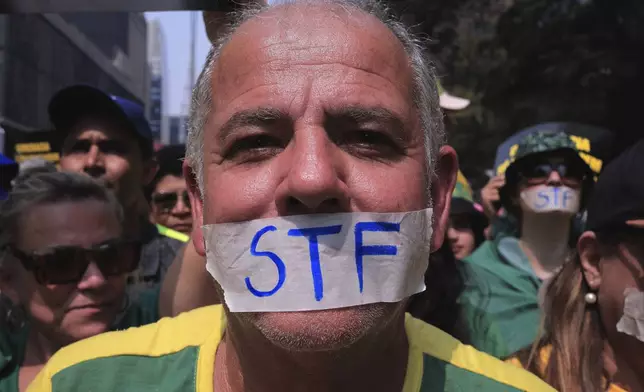 A demonstrator, his mouth covered with tape marked with the Brazilian Supreme Court acronym, takes part in a protest calling for the impeachment of Supreme Court Minister Alexandre de Moraes, who recently imposed a nationwide block on Elon Musk’s social media platform X, in Sao Paulo, Saturday, Sept. 7, 2024. (AP Photo/Ettore Chiereguini)