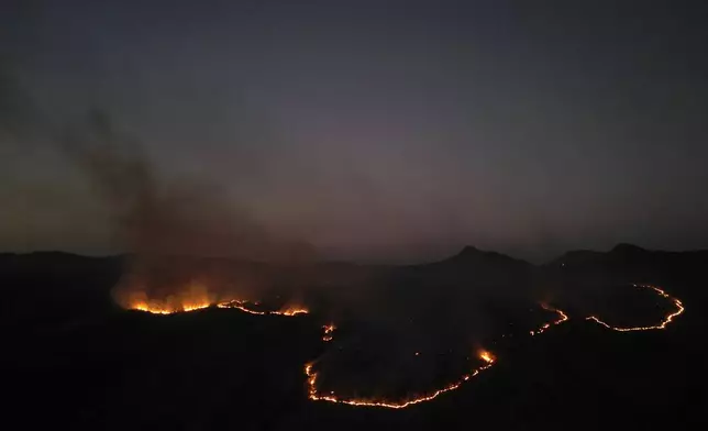 Fires spread through the environmental protection area of Pouso Alto, in Chapada dos Veadeiros National Park, during dry season, in Minas Sul, Goias state, Brazil, Monday, Sept. 9, 2024. (AP Photo/Eraldo Peres)