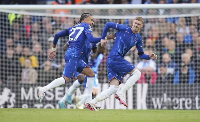 Chelsea's Cole Palmer, right, celebrates with his teammate Malo Gusto after scoring his side's 3rd goal during a British Premier League soccer match between Chelsea and Brighton at Stamford Bridge, London, Saturday, Sept. 28, 2024. (AP Photo/Kin Cheung)