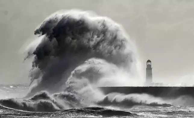 Waves crash against the lighthouse in Seaham Harbour, County Durham, England, Friday, Sept. 27, 2024. (Owen Humphreys/PA via AP)