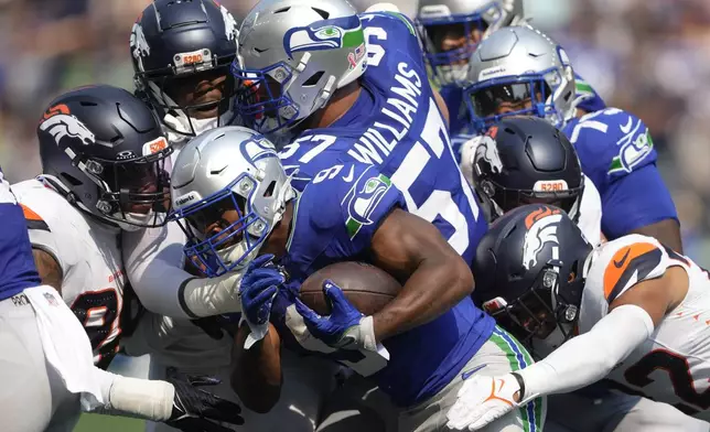 Seattle Seahawks running back Kenneth Walker III (9) is tackled by Denver Broncos players during the first half of an NFL football game Sunday, Sept. 8, 2024, in Seattle. (AP Photo/Lindsey Wasson)