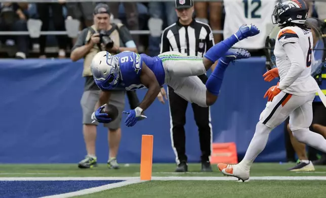 Seattle Seahawks running back Kenneth Walker III (9) leaps into the end zone for a touchdown during the second half of an NFL football game against the Denver Broncos, Sunday, Sept. 8, 2024, in Seattle. (AP Photo/John Froschauer)