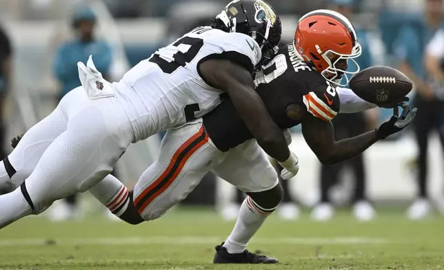 Cleveland Browns wide receiver Elijah Moore (8) drops a pass as he gets hit by Jacksonville Jaguars linebacker Devin Lloyd (33) during the second half of an NFL football game Sunday, Sept. 15, 2024, in Jacksonville, Fla. (AP Photo/Phelan M. Ebenhack)