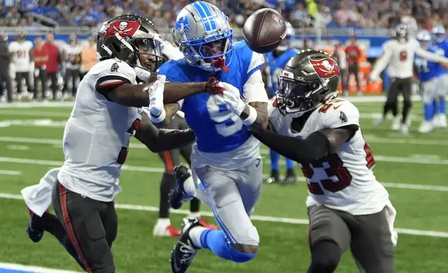 Tampa Bay Buccaneers safety Jordan Whitehead, left, and safety Tykee Smith (23) deflect the pass intended for Detroit Lions wide receiver Jameson Williams (9) during the first half of an NFL football game, Sunday, Sept. 15, 2024, in Detroit. (AP Photo/Paul Sancya)