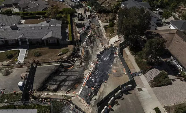 Collapsed roads are covered with tarps in a neighborhood damaged by ongoing landslides in Rancho Palos Verdes, Calif., Tuesday, Sept. 3, 2024. (AP Photo/Jae C. Hong)