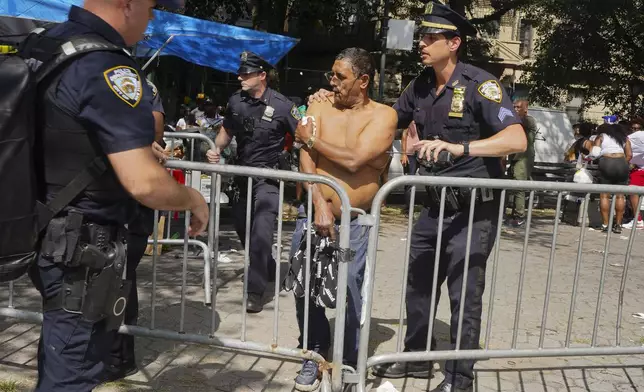 New York police officers escort a man injured during a shooting at the West Indian Parade, Monday, Sept. 2, 2024, in the Brooklyn borough of New York. (Nancy Siesel via AP)