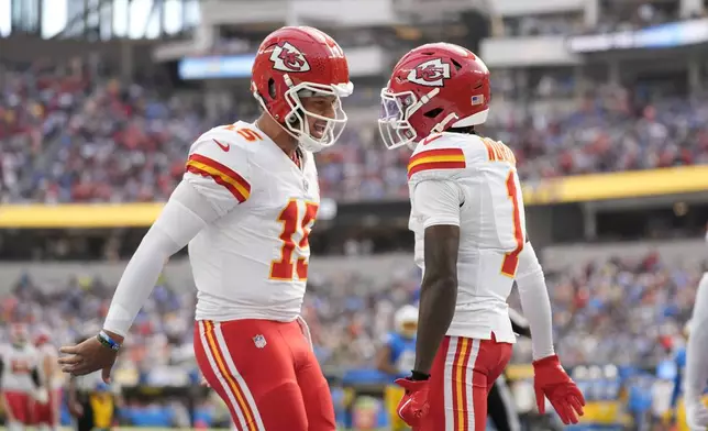 Kansas City Chiefs wide receiver Xavier Worthy, right, is celebrates after catching a 54-yard touchdown pass from teammate Patrick Mahomes, left, during the first half of an NFL football game against the Los Angeles Chargers Sunday, Sept. 29, 2024, in Inglewood, Calif. (AP Photo/Ashley Landis)