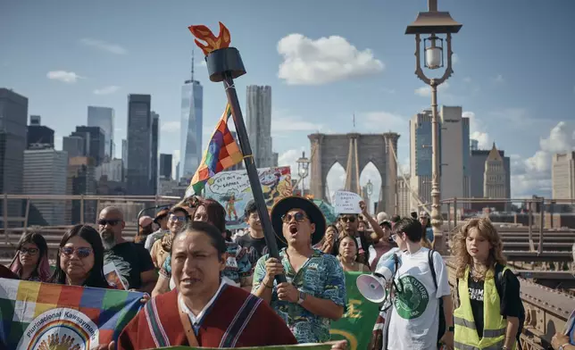 Protesters shout slogans as they cross the Brooklyn Bridge during a Youth Climate Strike march to demand an end to the era of fossil fuels, Friday, Sept. 20, 2024, in New York. (AP Photo/Andres Kudacki)