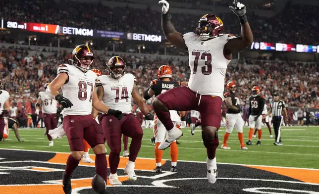 Washington Commanders offensive tackle Trent Scott (73) celebrates after catching a 1-yard touchdown pass during the second half of an NFL football game against the Cincinnati Bengals, Monday, Sept. 23, 2024, in Cincinnati. (AP Photo/Jeff Dean)