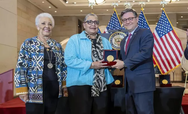 House Speaker Mike Johnson, R-La., center, presents a Congressional Gold Medal posthumously to Joylette Hylick, left, and Katherine Moore, daughters of Katherine Johnson, the Black NASA mathematician featured in the movie "Hidden Figures," at the Capitol in Washington, Wednesday, Sept. 18, 2024. (AP Photo/J. Scott Applewhite)