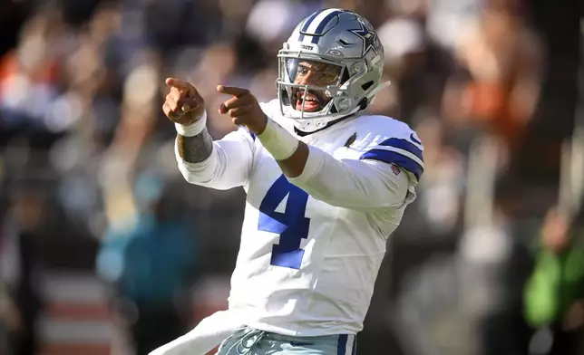 Dallas Cowboys quarterback Dak Prescott celebrates Ezekiel Elliott's touchdown run against the Cleveland Browns in the first half of an NFL football game in Cleveland, Sunday, Sept. 8, 2024. (AP Photo/David Richard)