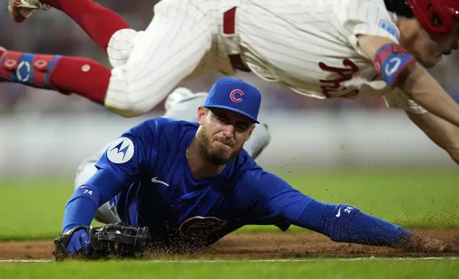 Chicago Cubs first baseman Cody Bellinger, bottom, cannot tag Philadelphia Phillies' Garrett Stubbs after Stubbs' run-scoring bunt single during the second inning of a baseball game, Tuesday, Sept. 24, 2024, in Philadelphia. (AP Photo/Matt Slocum)