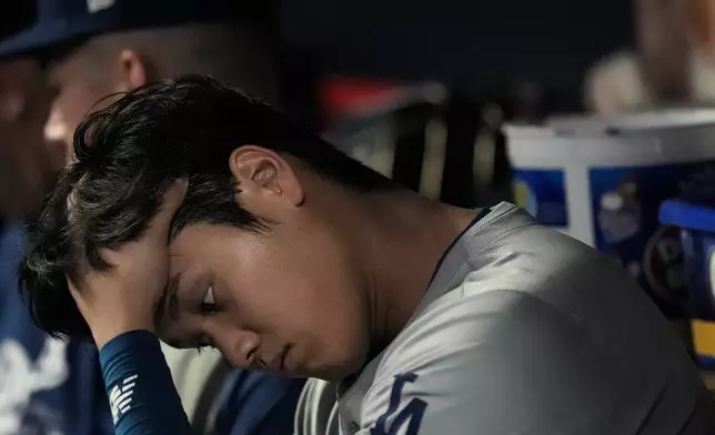 Los Angeles Dodgers two-way player Shohei Ohtani sits in the dugout in the sixth inning of a baseball game against the Atlanta Braves, Friday, Sept. 13, 2024, in Atlanta. (AP Photo/Mike Stewart)