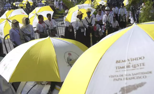 People wait for Pope Francis visiting to children with disabilities of the Irmas Alma School in Dili, East Timor, Tuesday, Sept. 10, 2024. (AP Photo/Dita Alangkara)