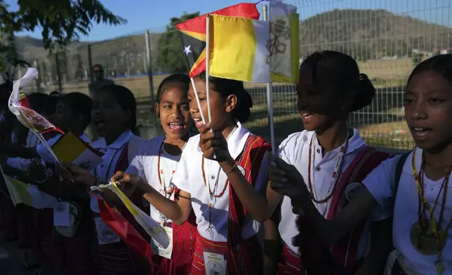 Students singi and chant on the side of the road outside the airport as they prepare to bid farewell to Pope Francis in Dili, East Timor, Wednesday, Sept. 11, 2024. (AP Photo/Dita Alangkara)