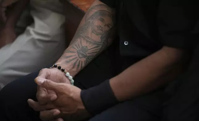 A man with an image of Jesus Christ tattooed on his arm attends a Sunday mass ahead of Pope Francis' visit to East Timor, at a church in Dili, Sunday, Sept. 8, 2024. (AP Photo/Dita Alangkara)