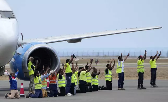 Airport staff wave to Pope Francis at Nicolau Lobato International Airport in Dili, East Timor, Wednesday, Sept. 11, 2024. (AP Photo/Dita Alangkara)