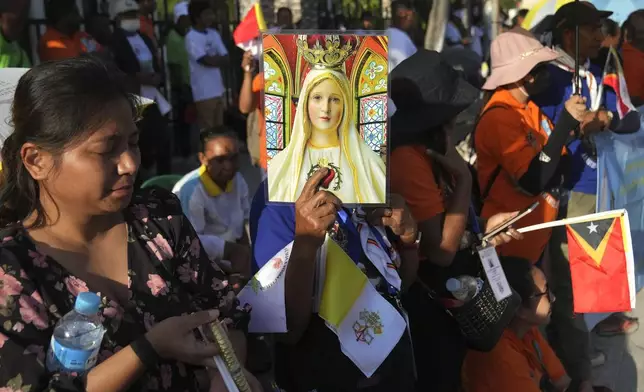 People wait for Pope Francis visiting to children with disabilities of the Irmas Alma School in Dili, East Timor, Tuesday, Sept. 10, 2024. (AP Photo/Dita Alangkara)