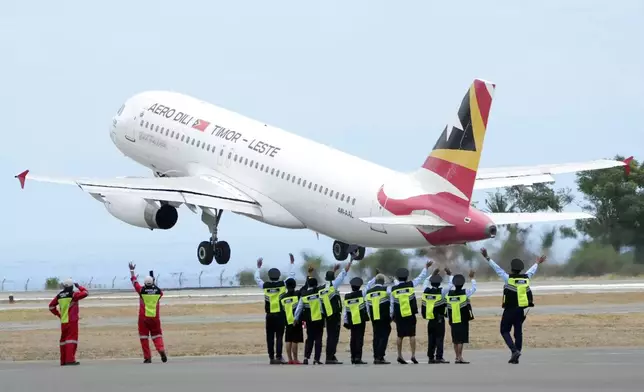 Airport staff wave to an airplane which Pope Francis aboard at Nicolau Lobato International Airport in Dili, East Timor, Wednesday, Sept. 11, 2024. (AP Photo/Dita Alangkara)