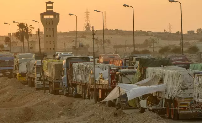 Trucks of humanitarian aids wait to cross the Rafah border crossing between Egypt and the Gaza Strip, in Rafah, Egypt, Monday, Sept. 9, 2024. (AP Photo/Amr Nabil)