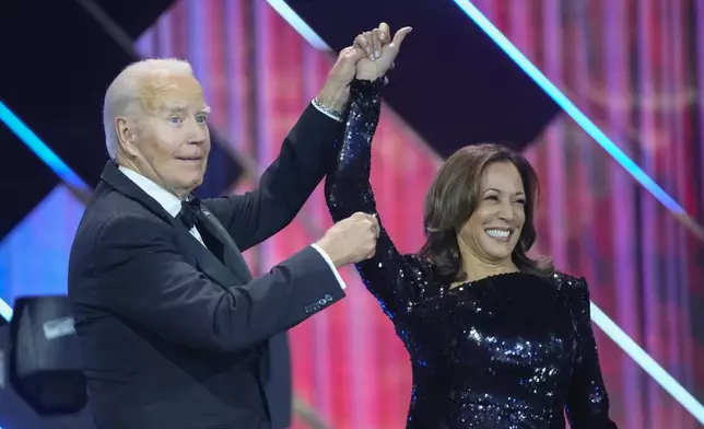 President Joe Biden, left, holds up the arm of Democratic presidential nominee Vice President Kamala Harris, right, while on stage at the Congressional Black Caucus Foundation's Phoenix Awards Dinner in Washington, Saturday, Sept. 14, 2024. (AP Photo/Mark Schiefelbein)