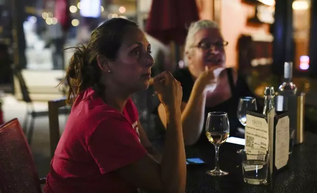 Christine Bell, left, 56, and Tara Correia, 56, watch the presidential debate between Republican presidential nominee former President Donald Trump and Democratic presidential nominee Vice President Kamala Harris at the Taste Food &amp; Wine, Tuesday, Sept. 10, 2024, in the Rogers Park neighborhood of Chicago. (AP Photo/Erin Hooley)