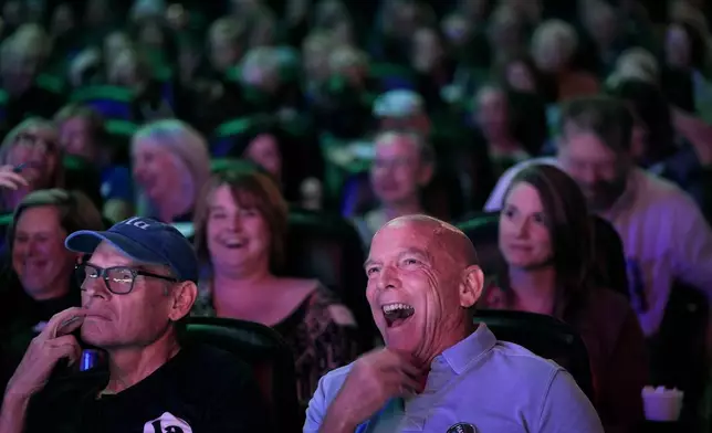 Chris Covert, front right, from Leawood, Kan., watches the presidential debate between Republican presidential nominee former President Donald Trump and Democratic presidential nominee Vice President Kamala Harris at a 97-year-old movie theater Tuesday, Sept. 10, 2024, in Shawnee, Kan. (AP Photo/Charlie Riedel)