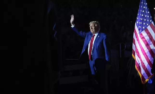 Republican presidential candidate former President Donald Trump waves to supporters as he arrives for a town hall event at the Dort Financial Center, Tuesday, Sept. 17, 2024, in Flint, Mich. (AP Photo/Evan Vucci)