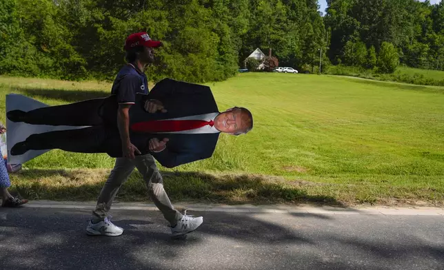 A supporters carries a stand-up of Republican presidential nominee former President Donald Trump after a campaign rally at North Carolina Aviation Museum, Wednesday, Aug. 21, 2024, in Asheboro, N.C. (AP Photo/Julia Nikhinson)