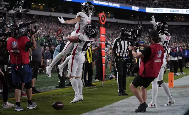 Atlanta Falcons wide receiver Drake London (5) celebrates his touchdown with teammate Chris Lindstrom (63) during the second half of an NFL football game against the Philadelphia Eagles on Monday, Sept. 16, 2024, in Philadelphia. (AP Photo/Matt Rourke)