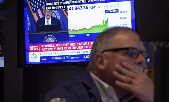 Trader Michale Conlon, right, works on the floor of the New York Stock Exchange as Federal Reserve Chair Jerome Powell's news conference appears on a television screen behind him, Wednesday, Sept. 18, 2024. (AP Photo/Richard Drew)