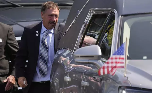 Guy Gaudreau looks into a hearse containing the remains of his son Columbus Blue Jackets hockey player John Gaudreau after his and his brother's Matthew Gaudreau funeral at St. Mary Magdalen Catholic Church in Media, Pa., Monday, Sept. 9, 2024. (AP Photo/Matt Rourke)