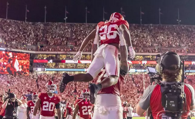 Alabama running back Jam Miller (26) celebrates his touchdown with offensive lineman Kadyn Proctor during the first half of an NCAA college football game against Georgia, Saturday, Sept. 28, 2024, in Tuscaloosa, Ala. (AP Photo/Vasha Hunt)