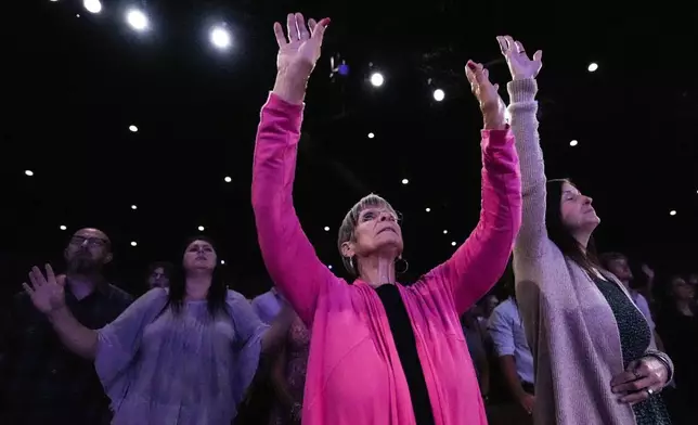 A member prays during a Sunday service at Bethlehem Church, Sunday, Sept. 8, 2024, in Bethlehem, Ga. Colt Gray, 14, has been charged with murder over the killing of two students and two teachers at Apalachee High School in Barrow County, outside Atlanta, on Wednesday. (AP Photo/Mike Stewart)