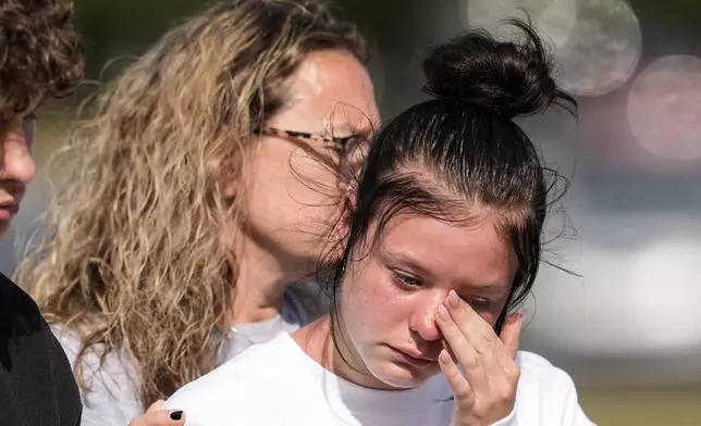 A student weeps at a makeshift memorial after a shooting Wednesday at Apalachee High School, Thursday, Sept. 5, 2024, in Winder, Ga. (AP Photo/Mike Stewart)