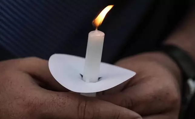 Mark Gorman holds a candle during a candlelight vigil for the slain students and teachers at Apalachee High School, Wednesday, Sept. 4, 2024, in Winder, Ga. (AP Photo/Mike Stewart)