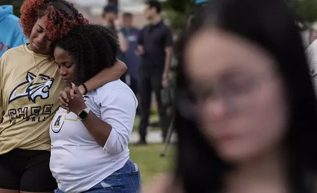 Mourners pray during a candlelight vigil for the slain students and teachers at Apalachee High School, Wednesday, Sept. 4, 2024, in Winder, Ga. (AP Photo/Mike Stewart)