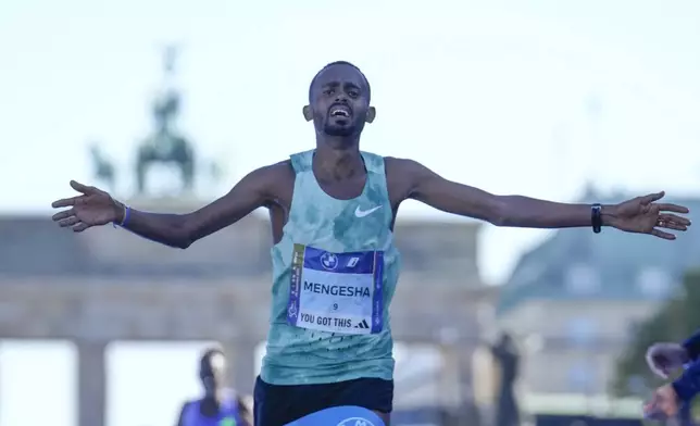 Milkesa Mengesha from Ethiopia celebrates as he crosses the finish line to win the men's division of the Berlin Marathon in Berlin, Germany, Sunday, Sept. 29, 2024. (AP Photo/Ebrahim Noroozi)