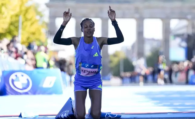 Tigist Ketema from Ethiopia celebrates as she crosses the finish line to win the women's division of the Berlin Marathon in Berlin, Germany, Sunday, Sept. 29, 2024. (AP Photo/Ebrahim Noroozi)