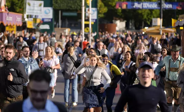 People run to enter the 189th 'Oktoberfest' beer festival in Munich, Germany, Saturday, Sept. 21, 2024. (AP Photo/Matthias Schrader)