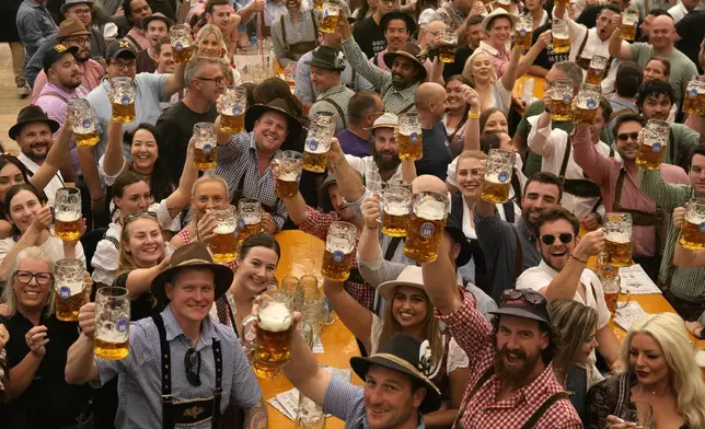 Festival enjoy the first glasses of beer on day one of the 189th 'Oktoberfest' beer festival in Munich, Germany, Saturday, Sept. 21, 2024. (AP Photo/Matthias Schrader)