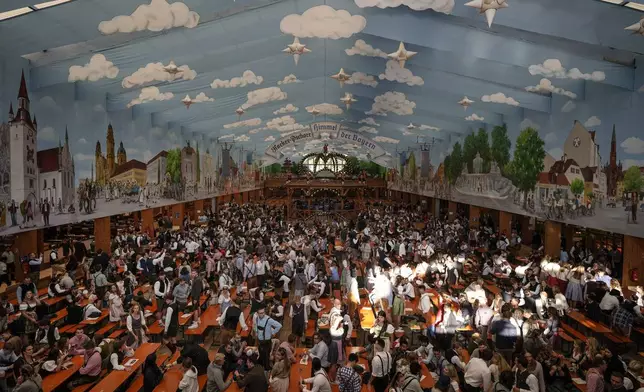 Visitors wait in the tent of the Hacker-Pschorr brewery the start of the 189th 'Oktoberfest' beer festival in Munich, Germany, Saturday, Sept. 21, 2024. (AP Photo/Matthias Schrader)