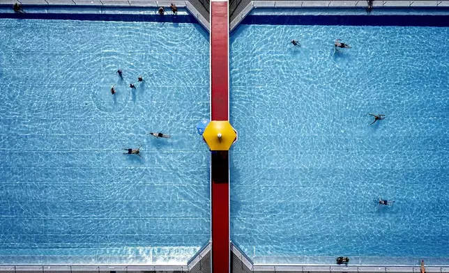 People swim in a public pool in Frankfurt, Germany, on a warm Tuesday, Sept. 3, 2024. (AP Photo/Michael Probst)