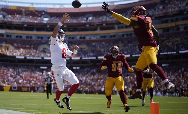 New York Giants quarterback Daniel Jones (8) throws an incomplete pass past Washington Commanders linebacker Frankie Luvu (4) on a two point conversion attempt during the first half of an NFL football game in Landover, Md., Sunday, Sept. 15, 2024. (AP Photo/Matt Slocum)