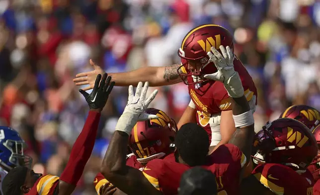 Washington Commanders place kicker Austin Seibert, top, celebrates with teammate after kicking the game-winning field goal against the New York Giants during the second half of an NFL football game in Landover, Md., Sunday, Sept. 15, 2024. (AP Photo/Steve Ruark)