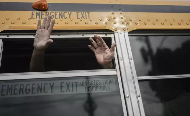 Nicaraguan citizens wave from a bus after being released from a Nicaraguan jail and landing at the airport in Guatemala City, Thursday, Sept. 5, 2024. (AP Photo/Moises Castillo)