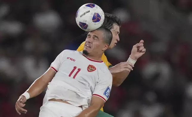 Indonesia's Ragnar Oratmangoen, left, battles for the ball against Australia's Craig Goodwin during the FIFA World Cup 2026 qualifier third round Group C Asia soccer match between Indonesia and Australia at Gelora Bung Karno stadium in Jakarta, Indonesia, Tuesday, Sept 10, 2024. (AP Photo/Achmad Ibrahim)