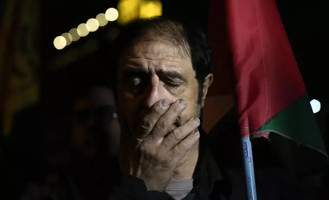 An Iranian demonstrator reacts while hearing news from Beirut during a gathering in support of Hezbollah at the Felestin (Palestine) Square in downtown Tehran, Iran, early Saturday, Sept. 28, 2024. (AP Photo/Vahid Salemi)